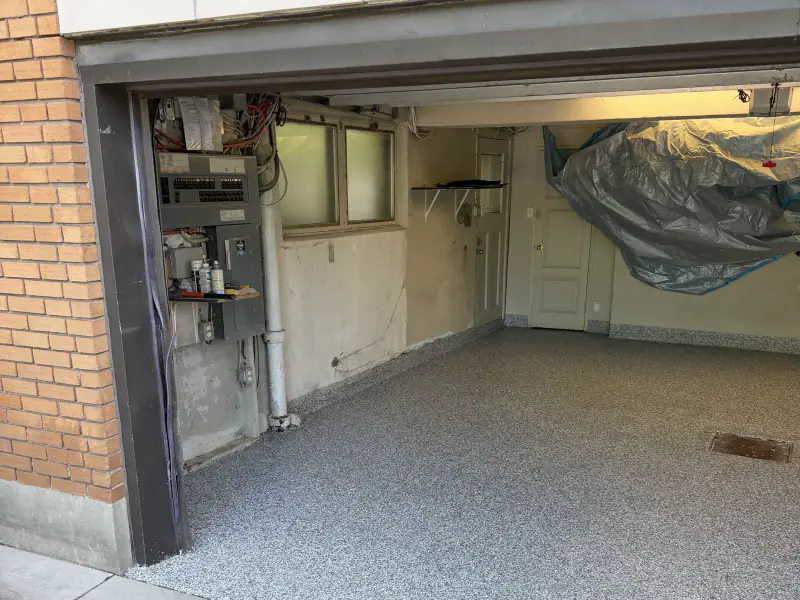 Residential garage seen from outside, floor finished in grey flake epoxy