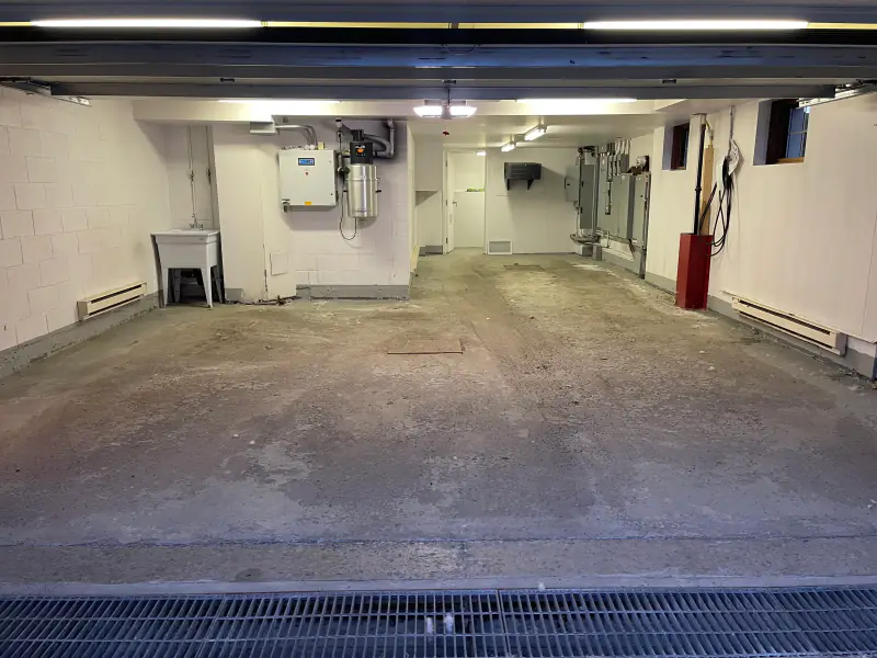 Double garage with a bare concrete floor, before the work