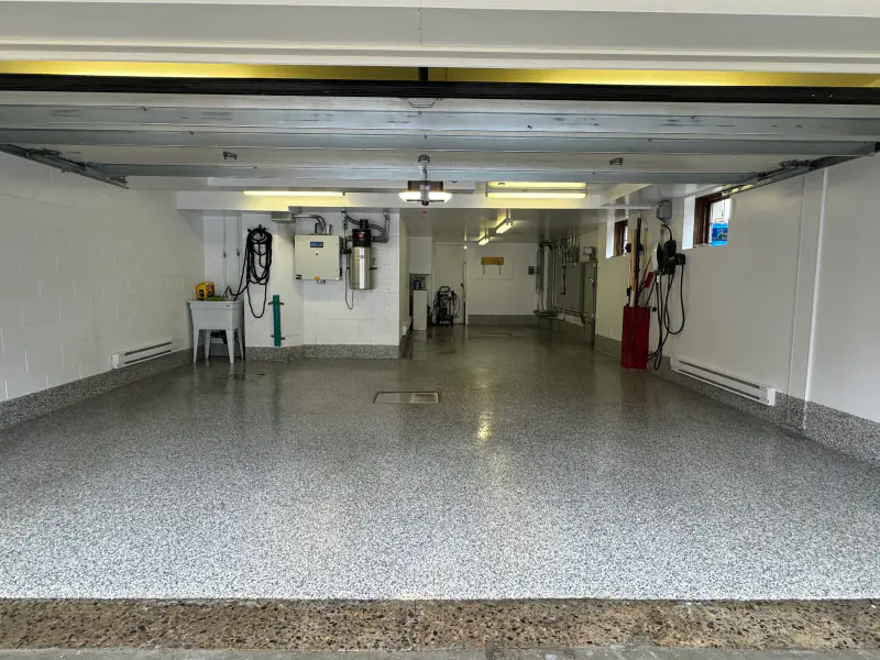 The same double garage finished, grey flake epoxy floor with an integrated cove base