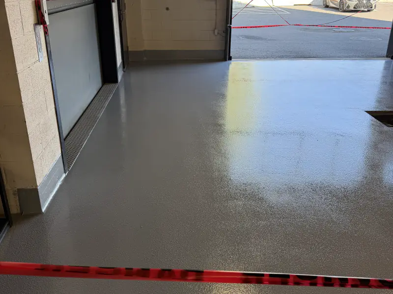 Solid grey epoxy floor in front of a commercial door
